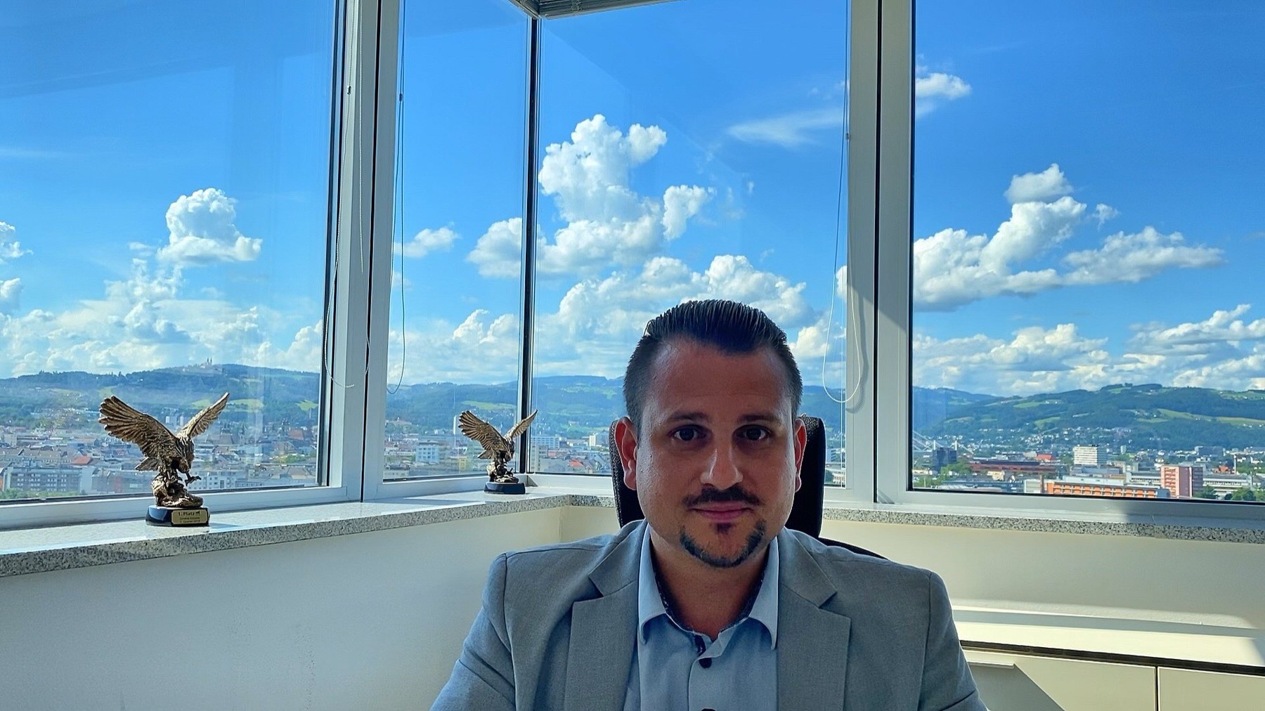 Roman Scheuchenstuhl im Büro im 16. Stock mit Blick über Linz